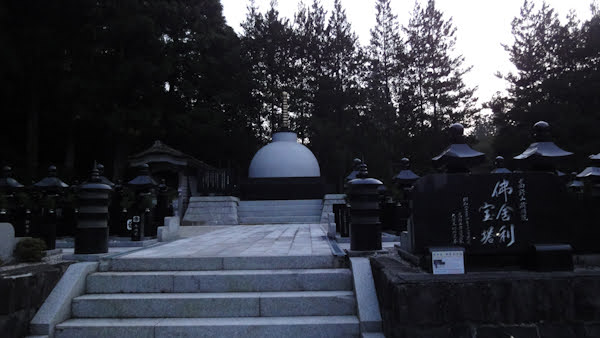 white stone steps lead to a raised section with white stone pathways, many dark unlit lanterns, and a white dome